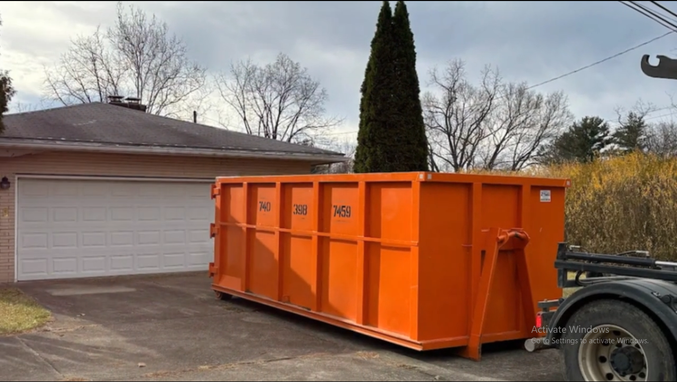 Home improvement debris being loaded into a roll-off dumpster